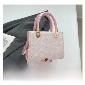 Pink woven texture handbag featuring gold hardware and pink braided handle detail