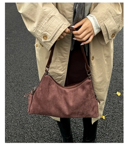 Détail du sac hobo en daim marron foncé avec bandoulière en cuir et fermeture éclair en argent