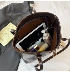Top-down view of large dark brown tote bag interior capacity with zipper and metal buckle