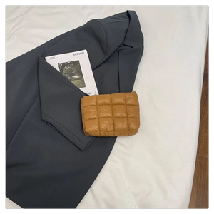 Detailed view of caramel quilted square pouch with puffy padding and grid stitching texture
