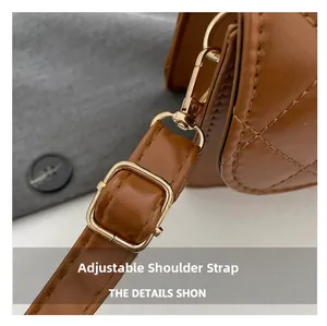 Detalle de la correa ajustable con herrajes dorados en bolso de cuero marrón acolchado