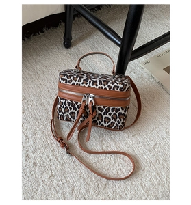 Détail du sac boîte à motif léopard avec poignées en cuir marron et double fermeture