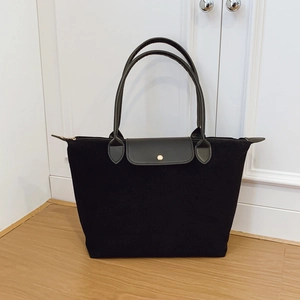 Classic black nylon tote bag with brown leather trim and golden snap button closure