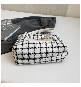 Detail of checkered tote bag with cat silhouette and elegant leather shoulder strap