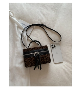Détail du sac boîte léopard avec fermetures éclair argentées et bandoulière réglable