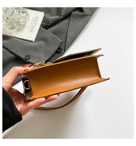 Détail des doubles compartiments et ferrures dorées sur sac bandoulière marron bicolore