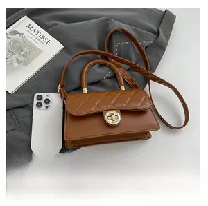 Detalle del bolso acolchado marrón con cierre dorado y smartphone para referencia de tamaño