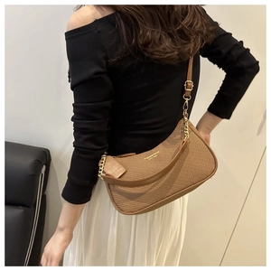 Detailed texture of brown woven shoulder bag with gold chain and logo accent