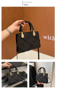 Detail of black textured square handbag with quilted stitching and bead embellishments
