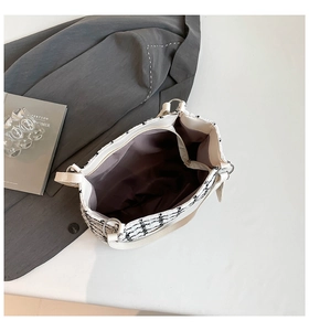 Top view of spacious tweed tote interior with a central zipper compartment and lining