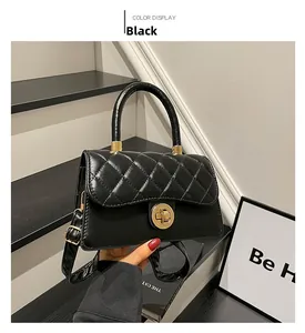 Détail d'un sac à main matelassé noir montrant le fermoir doré et la texture du cuir