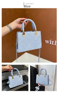Detail of light blue crossbody bag featuring white quilt patterns and floral embroidery