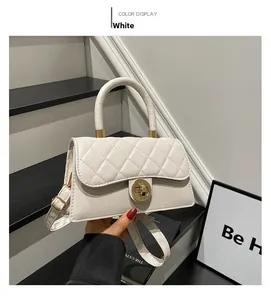 Vue détaillée d'un sac à main blanc matelassé avec fermoir tournant en métal doré