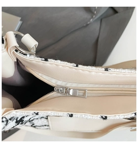 Detail of the high-capacity tote bag featuring tweed fabric and silver zipper closure