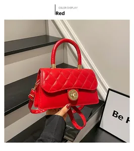 Détail d'un sac à main rouge matelassé avec fermoir rotatif doré et texture en cuir PU