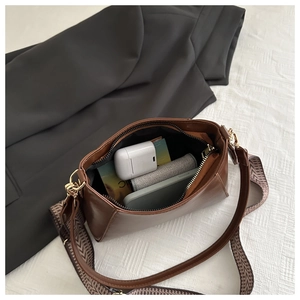 Detail view of the brown square bag interior showing phone and accessories storage