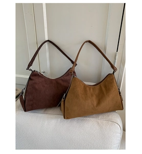 Détail de sacs portés épaule vintage en daim mat en couleurs marron foncé et camel
