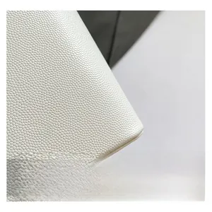 Close-up of the premium white lychee grain leather texture on a bucket bag detail