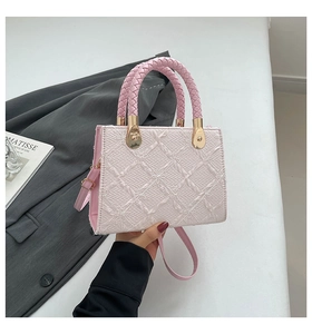 Detail of pink quilted leather tote with woven handles and gold metal hardware