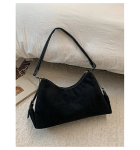 Gros plan sur un sac porté épaule noir mat avec des surpiqûres blanches contrastées