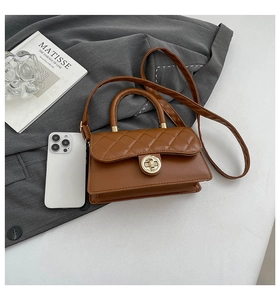 Close-up of dark brown quilted handbag with golden circular twist lock and leather texture