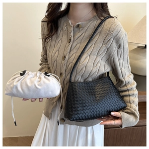 Dettaglio borsa a tracolla intrecciata nera con pochette color crema con coulisse