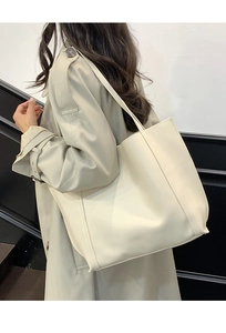 Vista laterale dettagliata della grande borsa tote off-white con cuciture e trama morbida