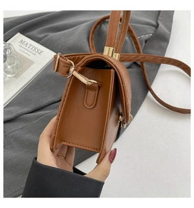 Detail view of brown quilted leather bag side profile with adjustable shoulder strap