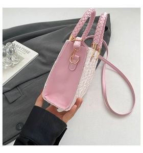 Detailed side view of pink handbag with woven texture and gold hardware accessories