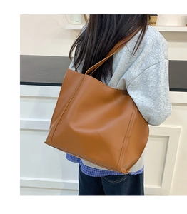 Dettaglio della grande borsa tote marrone in ecopelle testurizzata con cuciture verticali