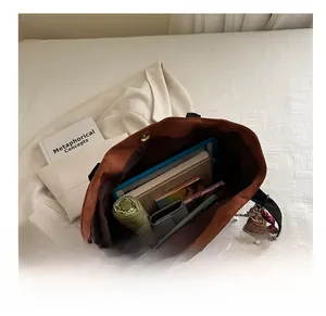 Vue de dessus du sac fourre-tout marron spacieux contenant tablette et accessoires