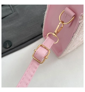 Detail of pink leather shoulder strap with gold buckle and white tweed fabric paneling