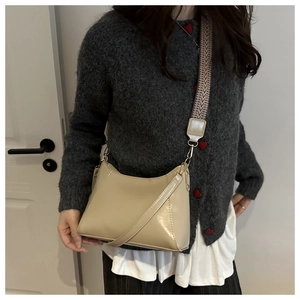 Detail of beige crescent crossbody bag with geometric pattern wide shoulder strap