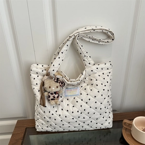 Borsa tote bianca trapuntata con cuori e ciondolo orsetto in ambiente domestico