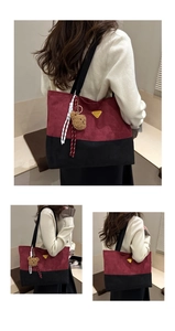 Détail du sac cabas bordeaux et noir avec charme ours en peluche et logo en métal