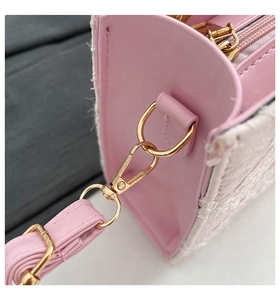 Detailed close-up of pink leather and white tweed stitching with gold metal clasps