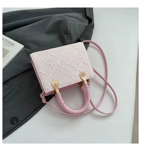 Macro shot of 3D floral texture and braided handle on light pink square handbag