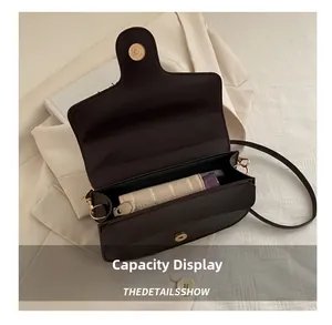 Internal capacity view of dark brown leather crossbody bag with golden buckle details
