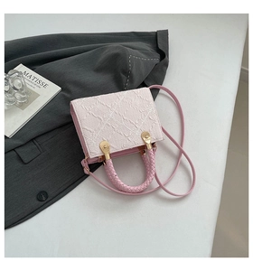 Detail of pink and beige crossbody bag featuring floral lace embroidery and gold hardware