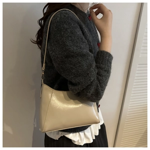 Detail view of beige vintage hobo bag with fine stitching and gold metallic buckle