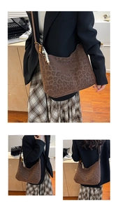 Detail of leopard print tote bag with vintage beaded charm and matte texture finish