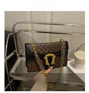 Detail of vintage patterned flap bag with gold chain strap and baroque buckle on display