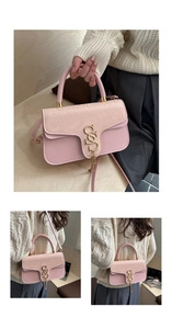 Detail of pink snakeskin pattern flap with gold logo and tassel on a chic crossbody bag