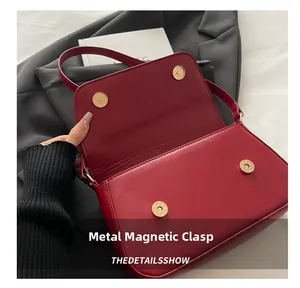 Detail of red PU leather bag showing magnetic hardware buckle and flap closure