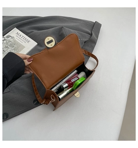 Internal view of the brown leather square bag showing phone and lipstick storage