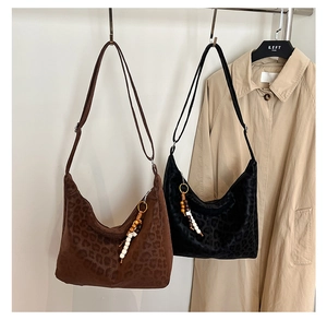 Detail of leopard print tote bags with beaded charms and soft suede-like texture