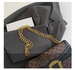 Detail of monogram pattern shoulder bag with golden chain straps and vintage buckle