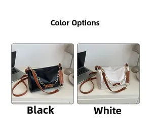 Détail de sacs cylindriques noirs et blancs avec chaîne à fleurs et bandoulière marron