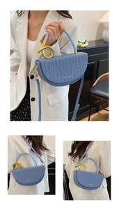 Macro view of blue woven saddle bag featuring a unique twisted golden metal handle detail