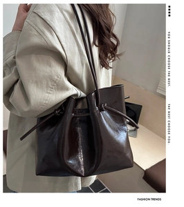 Detail of vintage brown leather tote bag with drawstring pleated texture and glossy finish